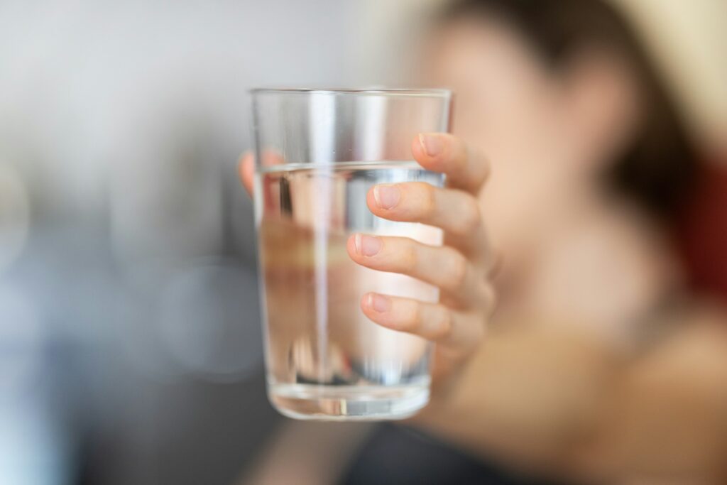 hand holding glass of water - one green filter